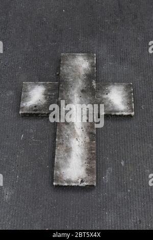 Betonkreuz mit weißer Form auf grauem Betongrund Stockfoto