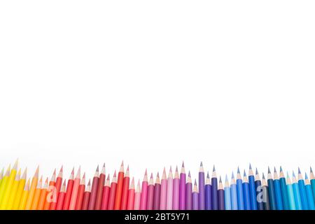 Bunte Buntstifte zum Zeichnen von Bildern und Skizzen. Auf weißem und gelbem Hintergrund. Draufsicht Stockfoto