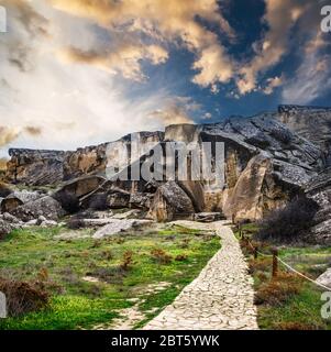 Gobustan Nationalpark alte Felsen, Felsweg und Berge in der Nähe von Baku in Aserbaidschan bei Sonnenuntergang. Stockfoto