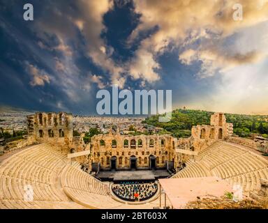 Panoramablick auf das antike Amphitheater Herodes Atticus mit Stadtbild im Hintergrund in der Akropolis bei Sonnenuntergang, Athen, Griechenland Stockfoto