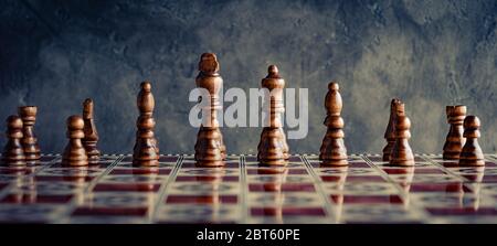 Klassische Holzschach-Figuren mit Reflexion an Bord vorne Stockfoto