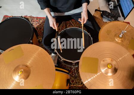 Übersicht über die Hände des jungen Schlagzeugers oder Musikers mit Drumsticks, die zu Hause, in der Garage oder im Studio zur freien Verfügung Proben Stockfoto