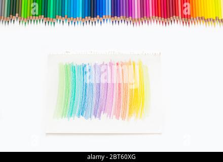 Bunte Buntstifte zum Zeichnen von Bildern und Skizzen. Auf weißem und gelbem Hintergrund. Draufsicht Stockfoto