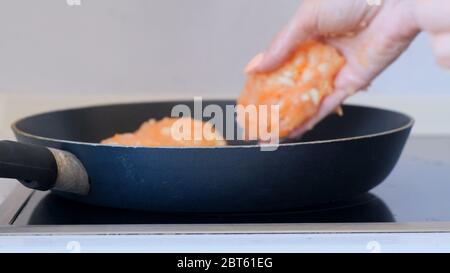 Koteletts in einer schwarzen Pfanne auf dem Herd gebraten. Stockfoto