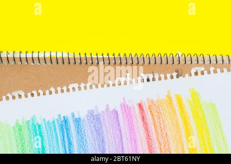 Bunte Buntstifte zum Zeichnen von Bildern und Skizzen. Auf weißem und gelbem Hintergrund. Draufsicht Stockfoto