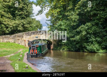 Ein Schmalboot, das sich an einem sonnigen sommertagstag im august in England unter einer Kanalbrücke auf dem Staffordshire und Worcestershire Kanal bahnte. Stockfoto