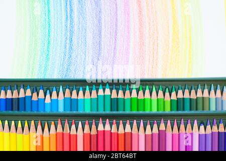 Bunte Buntstifte zum Zeichnen von Bildern und Skizzen. Auf weißem und gelbem Hintergrund. Draufsicht Stockfoto
