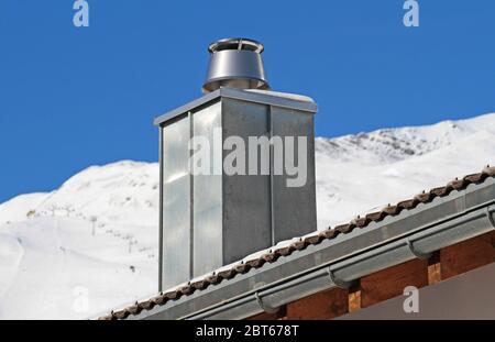 Metallkamin auf dem Dach der alpen Stockfoto