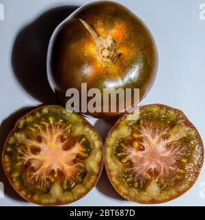 Frisches Paar Kumato Tomaten Eine Davon In Der Hälfte Auf Weißem Hintergrund Öffnen Stockfoto