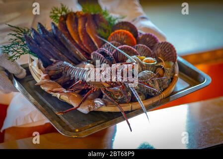 Kurs für frische Meeresfrüchte in Ama Divers’ Hut, japanisches Meeresfrüchte-BBQ. (Jakobsmuschel, Turban Shell, Squid, getrockneter Fisch, frischer Ise-ebi-Spiny-Hummer) Stockfoto