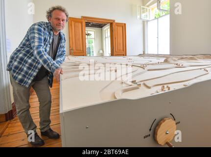 23. Mai 2020, Brandenburg, Altranft: Neben seiner Marmorbahn steht im Oderbruch Museum Altranft Reinier Scheers, Tischler und Designer des Modells. Reinier Scheers Aufgabe war es, das Strömungssystem des Oderbruchs mit Glasmurmeln sinnlich erlebbar zu machen. Das Ergebnis ist eine einzigartige Marmorbahn einer Region in Ostbrandenburg. Die Marmorbahn wird nicht mit elektrischer Energie betrieben. Nur Mechanik und Schwerkraft treiben dieses neue Highlight des Museums an. Und wer das Museum kennt, weiß, dass hier alles berührt werden kann oder sollte: Lernen durch Spielen, Lernen durch Berührung ist das Programm dort. Th Stockfoto