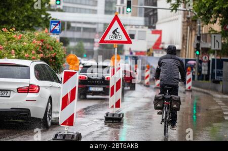 Stuttgart, Deutschland. Mai 2020. Eine Radfahrerin fährt ihr Fahrrad im Regen auf einem von Greenpeace-Aktivisten erstellten Pop-up-Radweg. Eine Spur wurde für Autos gesperrt und für Radfahrer geöffnet. Quelle: Christoph Schmidt/dpa/Alamy Live News Stockfoto