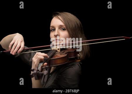 Professionelle leidenschaftliche Geigerin auf einer antiken handgefertigten Holzbarocke Geige spielen während eines Konzerts oder Live-Performance mit Fokus auf th Stockfoto