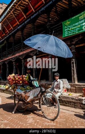 Kathmandu, Bhaktapur. Bunte Straßenszene mit einem Markthändler in der mittelalterlichen Stadt Bhaktapur aus dem 17. Jahrhundert während des Bada Dasain Festivals Stockfoto