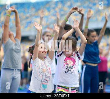 Zwei kleine Mädchen in Sportbekleidung machen Übungen auf dem Stadion, Hände hoch. Oktober 16, 2019. Kiew, Ukraine Stockfoto