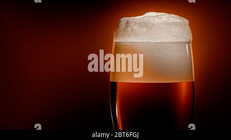 Lagerbier setzt sich im Glas mit einer weißen Schaumkappe ab Stockfoto