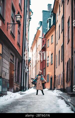 Eine Person, die in Gamla Stan Stockholm einen mit Schnee bedeckten Bürgersteig hinuntergeht. Hochwertige Fotos Stockfoto