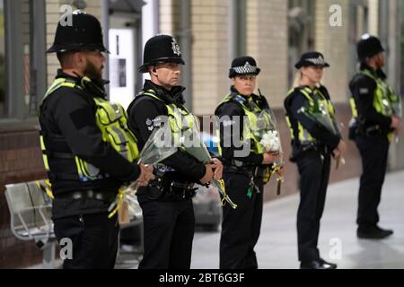 Manchester, Großbritannien. Mai 2020. Polizisten halten Blumensträuße in der Schlange am Bahnhof von Manchester Victoria, um den 3. Jahrestag der Manchester Arena Bombe in Manchester, Großbritannien, zu feiern. Kredit: Jon Super/Alamy Live News. Stockfoto