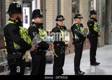 Manchester, Großbritannien. Mai 2020. Polizisten halten Blumensträuße in der Schlange am Bahnhof von Manchester Victoria, um den 3. Jahrestag der Manchester Arena Bombe in Manchester, Großbritannien, zu feiern. Kredit: Jon Super/Alamy Live News. Stockfoto