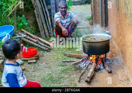 Gorkha, Nepal - Oktober 6,2019: Alter Mann kocht Mutton Curry im ländlichen Dorf Nepal. Hammelcurry.Selektiver Fokus Stockfoto
