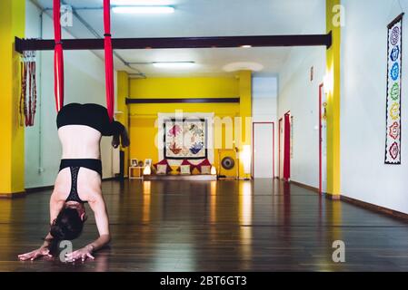 Junge Frau, die Yoga-Akrobatik in der Luft auf einer Schaukel. Konzept der Yoga-Akrobatik Stockfoto