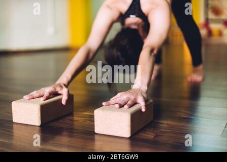 Frau, die Yoga-Übungen mit Ziegeln für Yoga macht. Konzept der Yoga-Übungen Stockfoto