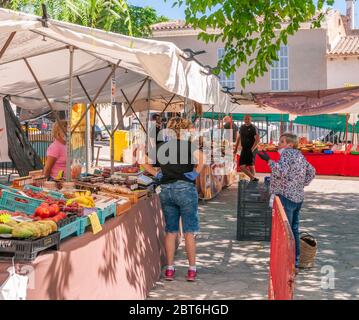 Sineu, Balearen/Spanien; 20. Mai 2020: Obst- und Gemüsestand auf dem traditionellen Straßenmarkt in Sineu. Verkäufer und Käufer mit Handschuhen und Mas Stockfoto