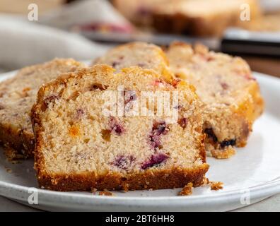 Nahaufnahme von in Scheiben geschnittenen Cranberry-Orangenkuchen auf einem weißen Teller Stockfoto
