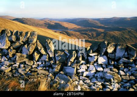 Trockener Steindeich im Schnee auf Benyellary, Abstieg von Merrick, Galloway Forest Park, Stockfoto