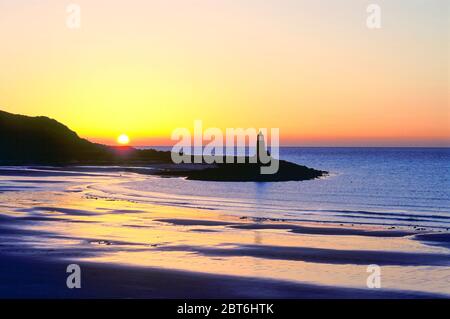 Port logan Bay bei Sonnenuntergang mit altem Leuchtturm, Rhinns of Galloway Stockfoto