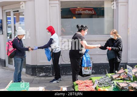 London, Großbritannien. Mittwoch, 23. Mai 2020. Käufer und Verkäufer tragen Schutzmasken auf einem Bauernmarkt in West Ealing, London während der Coronavirus-Krise. Foto: Roger Garfield/Alamy Quelle: Roger Garfield/Alamy Live News Stockfoto