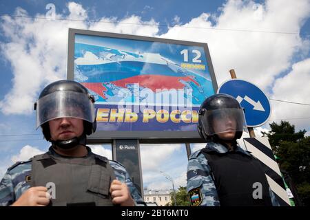 Moskau, Russland. 12. Juni 2013 EIN Festplakat mit der Aufschrift "Russia Day on June 12" auf dem Bolotnaya Platz mit einem Polizeikordon während einer Oppositionsskundgebung in Moskau, Russland Stockfoto