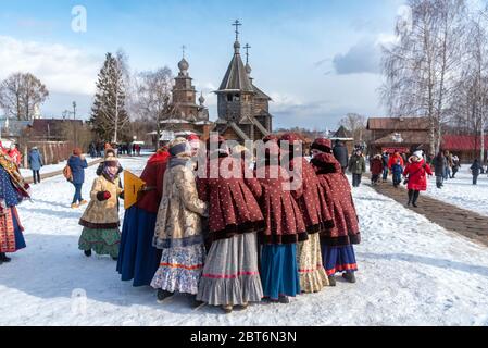 Frauen, die traditionelle russische Schals und Kostüme tragen, singen und tanzen für das russische Volksfest Maslenitsa in Susdal. Unterhaltung. Winterspaß. Stockfoto