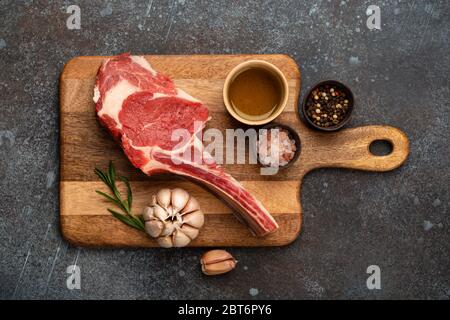 Rohes marmoriertes Fleischsteak auf Holzbrett Stockfoto