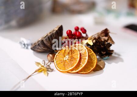 Auf weißem Hintergrund sind Details, getrocknete Orangen, Zweige und Beeren zur Dekoration, Stockfoto