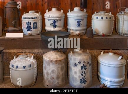 tokio, japan - märz 30 2020: Alte Keramik Sake Fass Flaschen auf dem Regal des Yoshidaya traditionellen japanischen Sake Schnaps-Shop rehabilitiert als ein Stockfoto