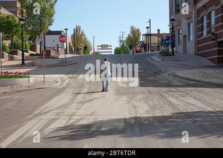 Midland, USA. Mai 2020. Ein Mann geht am 22. Mai 2020 einen Schlamm hinauf, der von der Straße in Midland, MI, blockiert wurde, nachdem zwei Dämme stromaufwärts versagt hatten. Ausfälle der Dämpel von Edenville und Sanford in der Teustag-Nacht haben dazu geführt, dass 10,000 Menschen ihre Häuser evakuieren. Entlang des Tittabawassee wurden Häuser zerstört, Straßen blockiert und mit Wasser bedeckt, sowohl unter als auch über den Dämmen. (Foto: Coleman Camp/Sipa USA) Quelle: SIPA USA/Alamy Live News Stockfoto