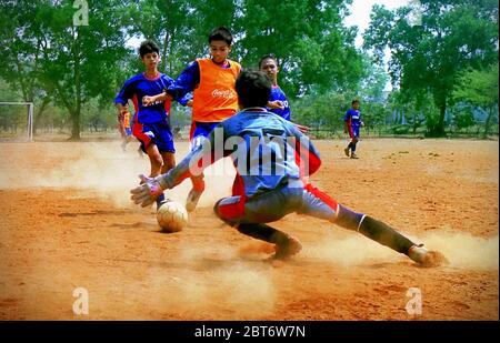 Junge indonesische Fußballspieler der SSB (Fußballschule) Tunas Patriot haben ein Spiel auf einem staubigen Feld in Bekasi, West Java, Indonesien. Archivfoto (2002). Stockfoto