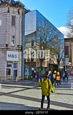 Shopper genießen die Wintersonne, während sie am Marks & Spencer Store in Cardiff's Queen Street vorbeischlendern. Stockfoto