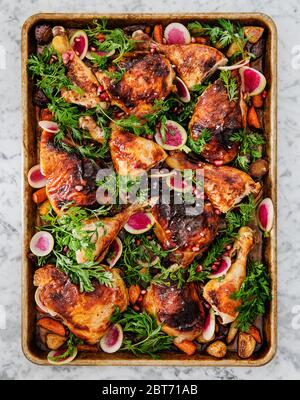 Gebratenes Huhn mit Karotten, Radieschen und Granatapfel Stockfoto