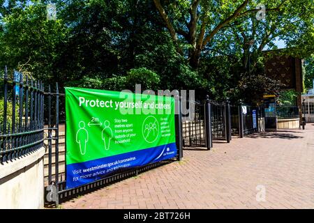 21 May 2020, London, UK - Schild an den Toren der Victoria Embankment Gardens, um Menschen mit einer Entfernung von 2 Metern daran zu erinnern, die Regierungsanweisungen zur Verhinderung der Ausbreitung des Coronavirus während der Pandemiesperre zu befolgen Stockfoto