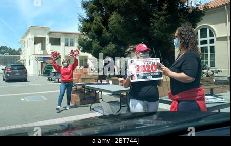 San Mateo, USA. Mai 2020. Mitarbeiter begrüßen die Absolventen der Burlingame High School in San Mateo County, USA, am 22. Mai 2020. Die Schule hielt Drive-Thru-Abschluss für die Klasse von 2020 aufgrund COVID-19. Kredit: Wu Xiaoling/Xinhua/Alamy Live News Stockfoto