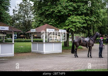 Feature, Dekorationsbild, Hintergrund, Hintergrundbild, Symbol, Symbolbild: Vor einem leeren Verkaufsstand befindet sich ein Bräutigam mit Schutzmaske. GES/Gallop Sport/Iffezheim Spring Metting, 23. Mai 2020 23. Mai 2020 Horseracing Spring Festival, Iffezheim, 23. Mai 2020 weltweit Stockfoto