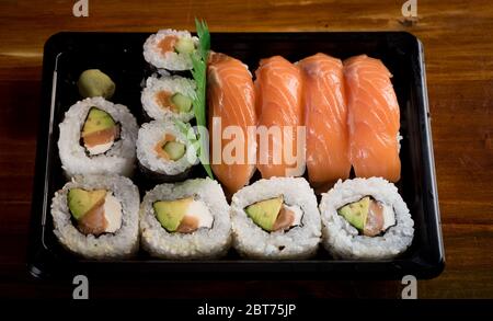 Drei Maki-Rollen in einer Reihe mit Lachs, Aal und Gurke auf weißem Hintergrund isoliert. Frische Hosomaki-Stücke mit Reis und Nori. Nahaufnahme von Delicious j Stockfoto