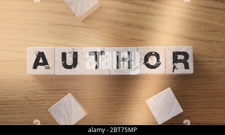 Autorenwort aus Holzwürfeln mit Buchstaben auf einem Holztisch Stockfoto
