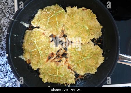 Holunderblüten in Pfannkuchen Teig immer in der Pfanne frittiert, Stockfoto