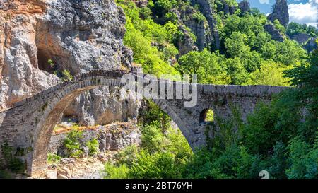 Die Noutsou-Brücke (oder Kokkori, wie sie auch genannt wird), eine einzige Bogensteinerne Brücke, befindet sich im Zentrum von Zagori, zwischen den Dörfern von Koukouli Stockfoto