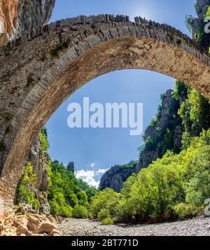 Die Noutsou-Brücke (oder Kokkori, wie sie auch genannt wird), eine einzige Bogensteinerne Brücke, befindet sich im Zentrum von Zagori, zwischen den Dörfern von Koukouli Stockfoto