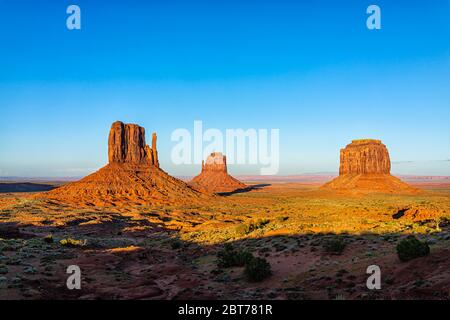 Weitwinkelansicht der berühmten Buttes und Horizont in Monument Valley bei Sonnenuntergang lebendiges, buntes Licht in Arizona mit orangefarbenen Felsen Stockfoto