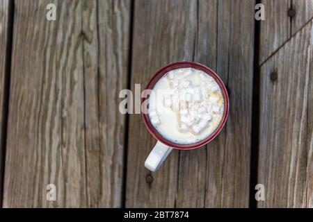 Nahaufnahme flache Ansicht von einer heißen Schokolade oder Kaffeetasse mit festlichen Marshmallow weißen Schaum Cappuccino oder Weihnachtskakao Getränk auf Holztisch outsi Stockfoto